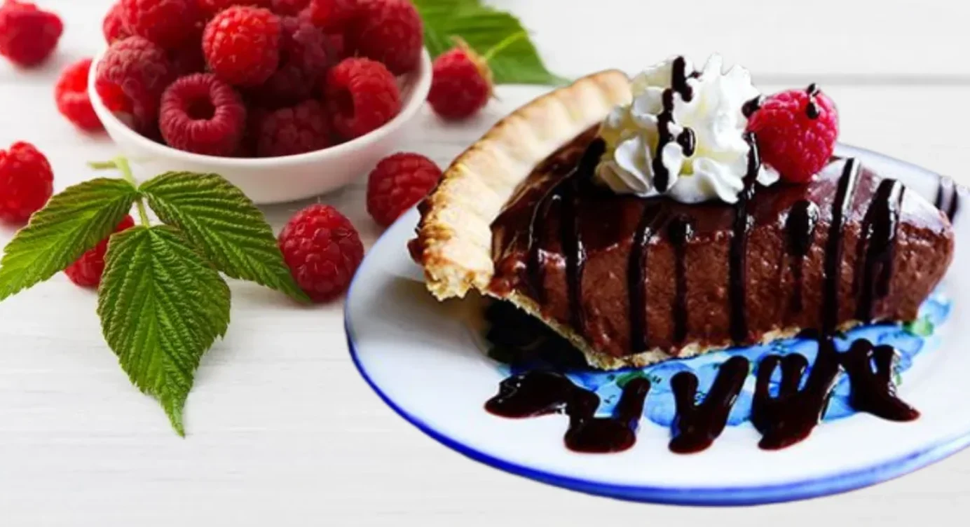 Tarte au chocolat avec de la chantilly, framboise et sirop au chocolat